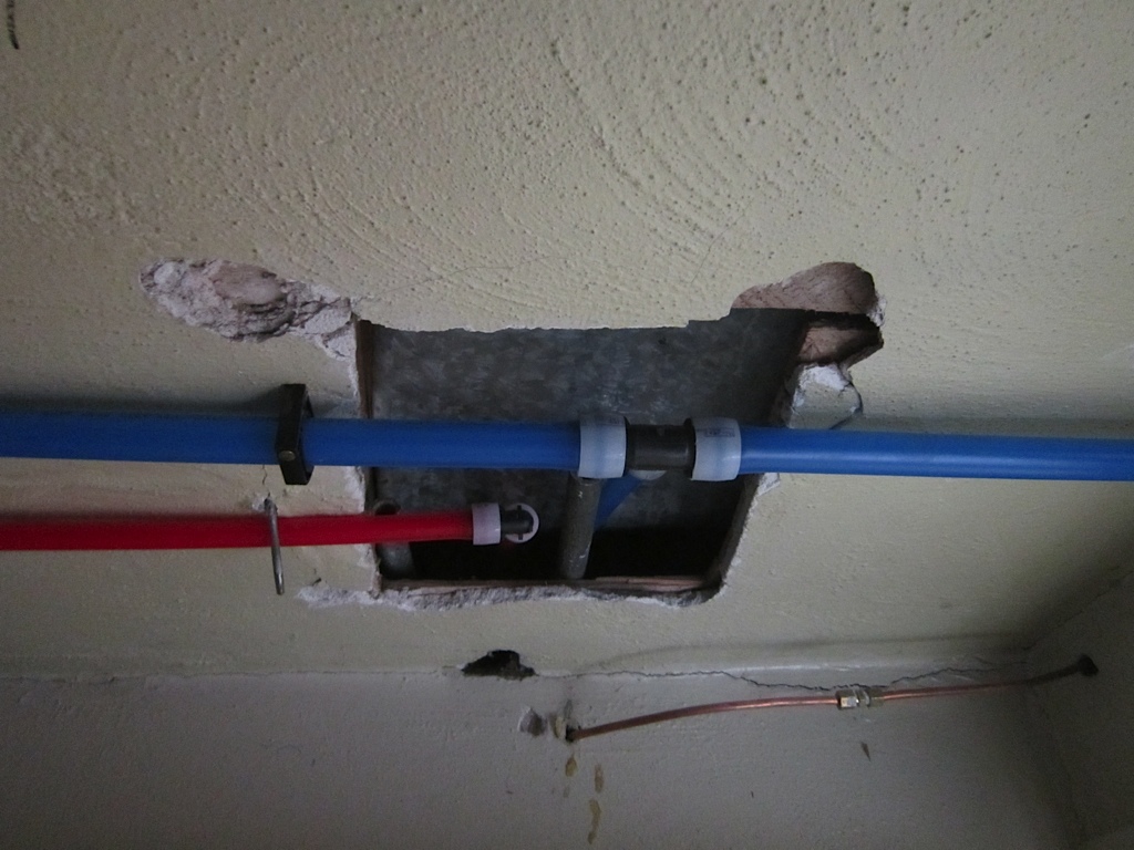 ceiling with hole under pipes