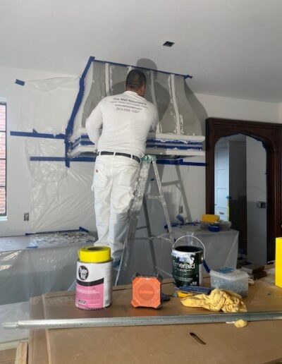 A man finishing a stove hood