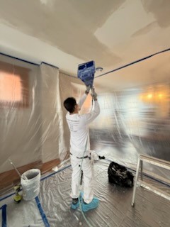 workman spraying texture on a ceiling
