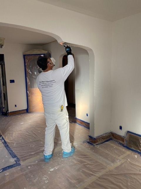 A workman working on a pass-through arch in Denver
