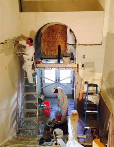 workmen plastering a school The Wall Rebuilders Colorado