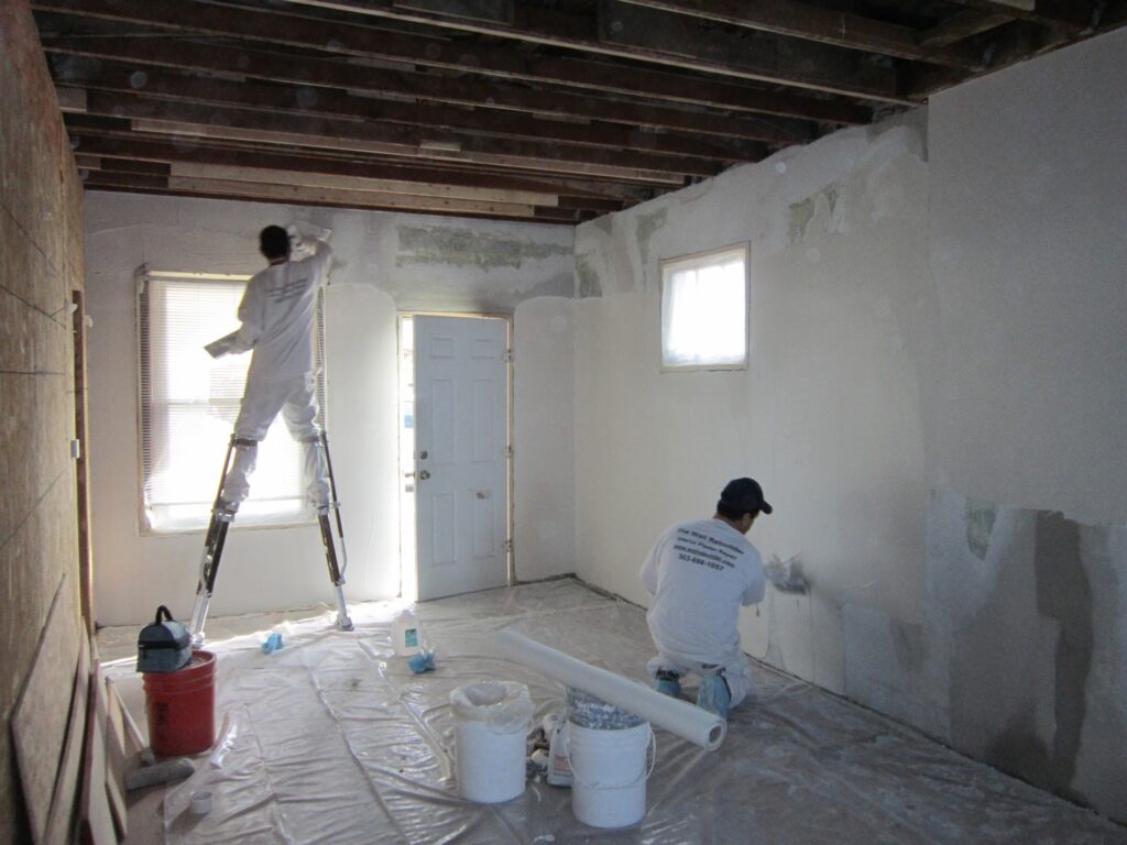 men repairing plaster in a room in Denver, CO