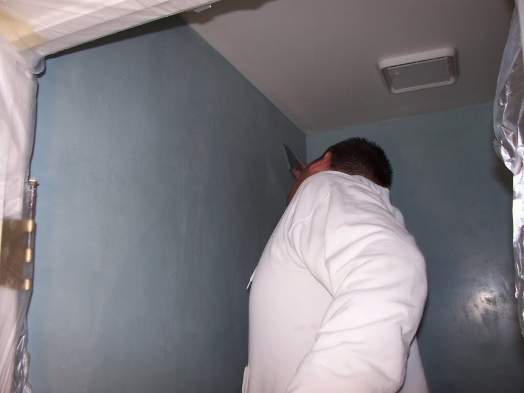 workman applying blue Venetian plaster in a bath in Denver